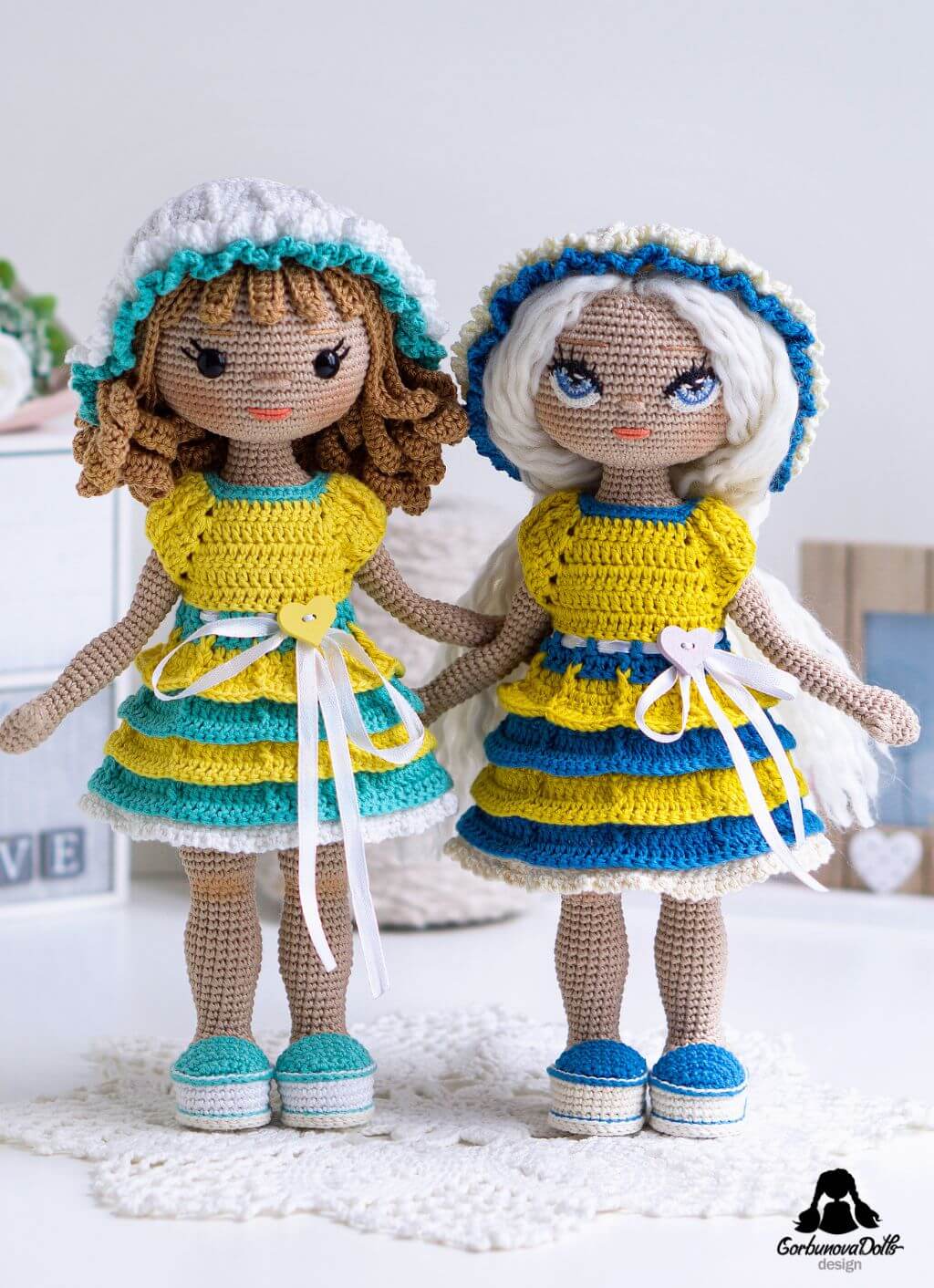 Crochet doll pattern with clothes - two finished amigurumi dolls showing removable outfits, seamless no-sew bodies, crocheted eyes and safety eyes options, curly crocheted wig and yarn hair styles