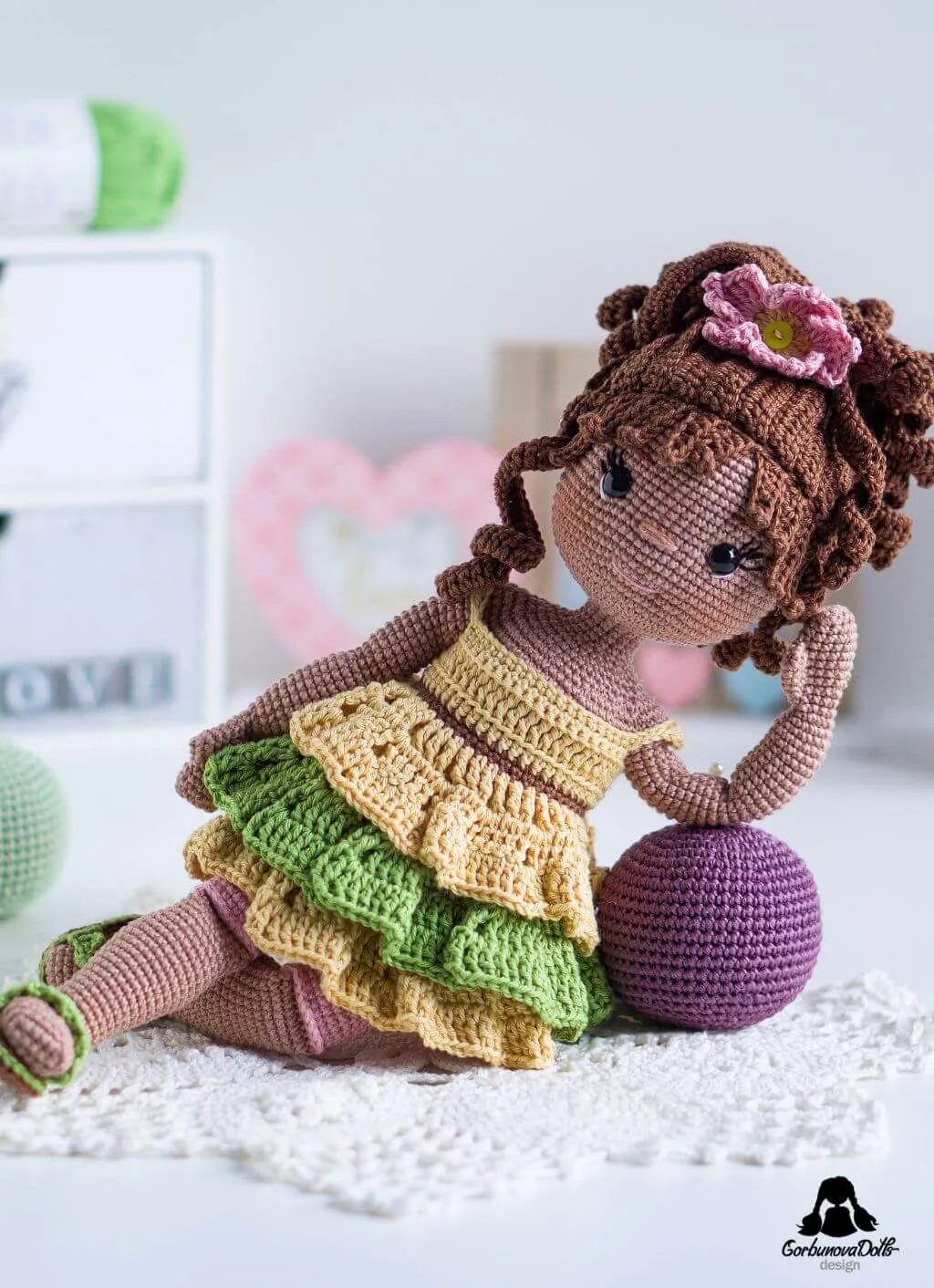 Finished Emily crochet doll resting on a ball, made using the amigurumi doll pattern