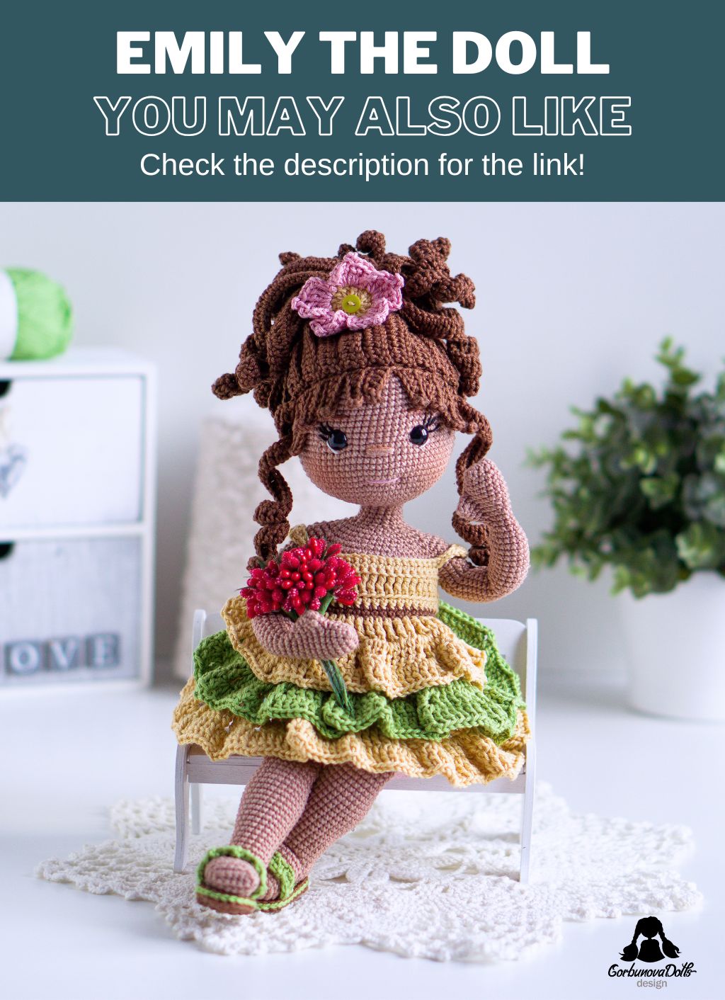 Crocheted Emily doll made from an amigurumi doll pattern, sitting on a bench and waving hello