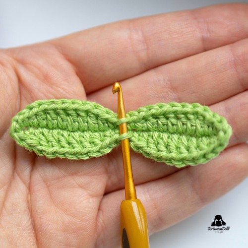 crochet tulip keychain tutorial – hook inserted through leaf stitches to pull the stem chain