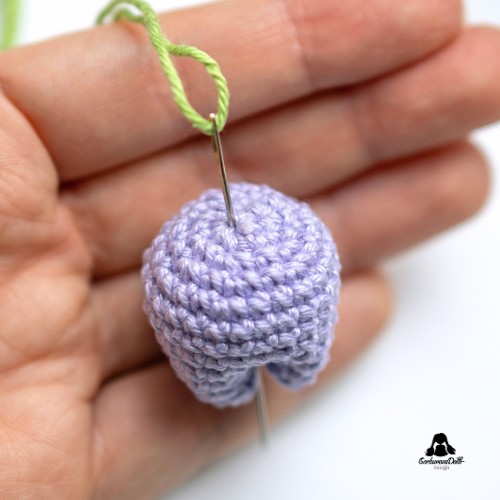crochet tulip keychain tutorial – sewing the stem to the bottom of the tulip flower with a yarn needle