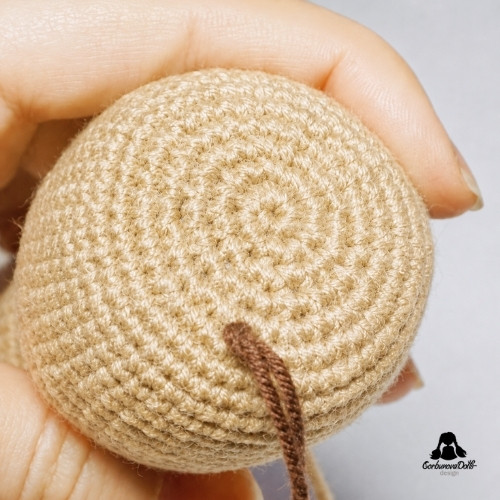 crochet doll hair tutorial – one yarn hair strand secured on the doll head