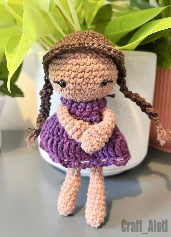 Ellie crochet doll pattern with purple dress and braided hair